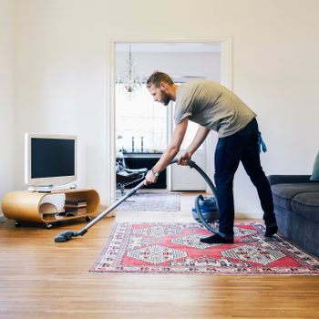A man vacuuming his home