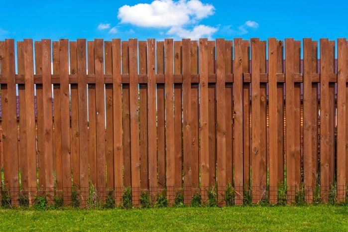 shadow box Wooden fence with green grass in front and blue sky behind