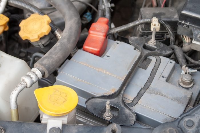 Car battery and windshield washer. Close up detail of a Flat-four (boxer) car engine compartment under the open hood