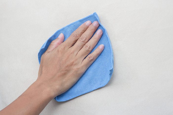 Microfiber Cloth cleaning a dirty wall