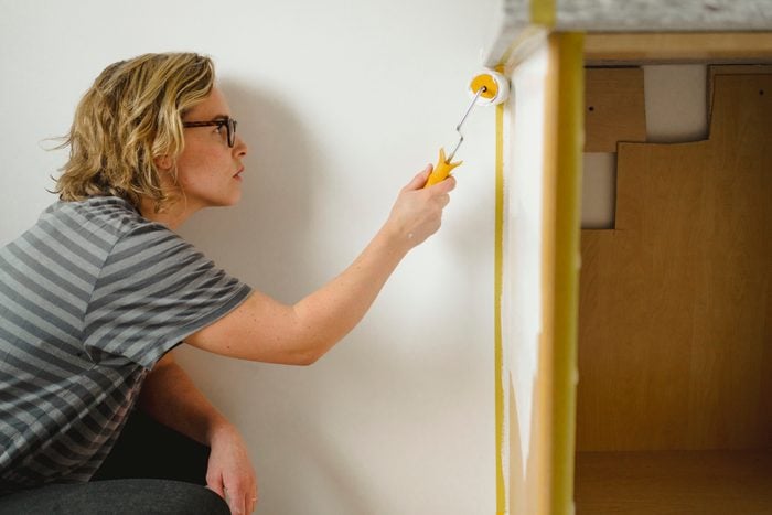 Woman painting kitchen cabinets