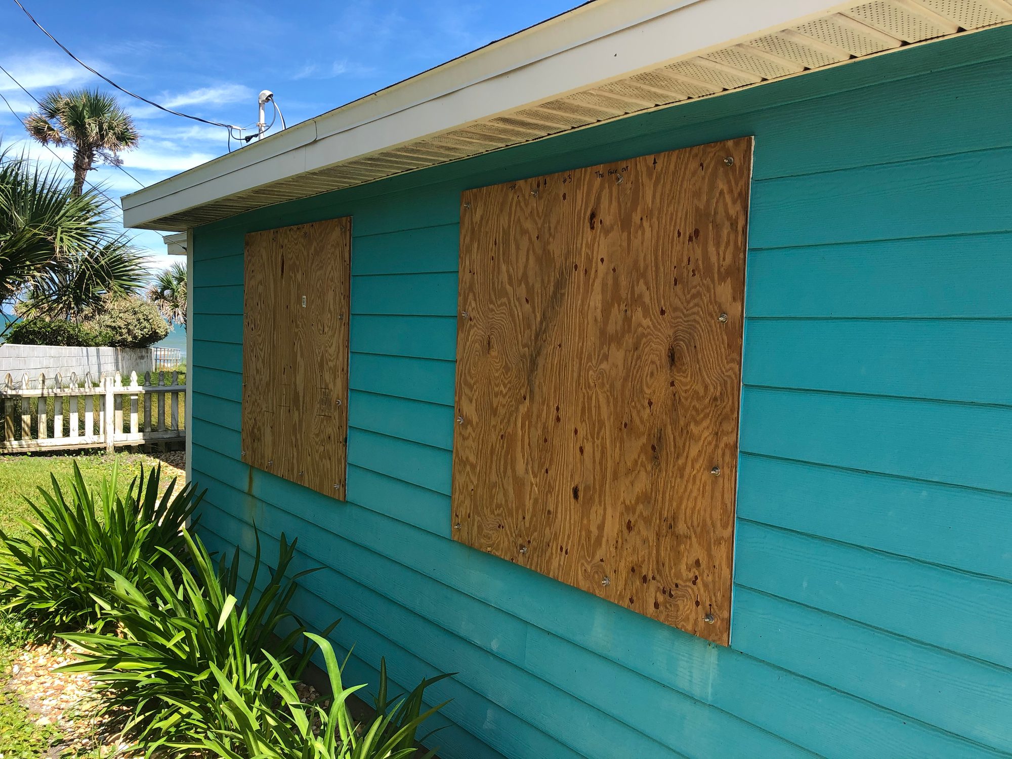 Plywood covers the windows of a beach cottage in Florida in preparation for an oncoming hurricane
