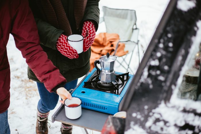 Making coffee on portable camp stove outside in the winter time
