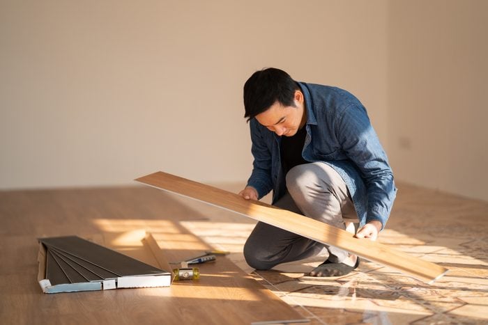 Carpenter is working on SPC flooring inside the house.