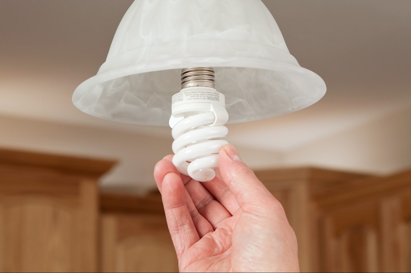 Hand Installing Compact Florescent Light Bulb