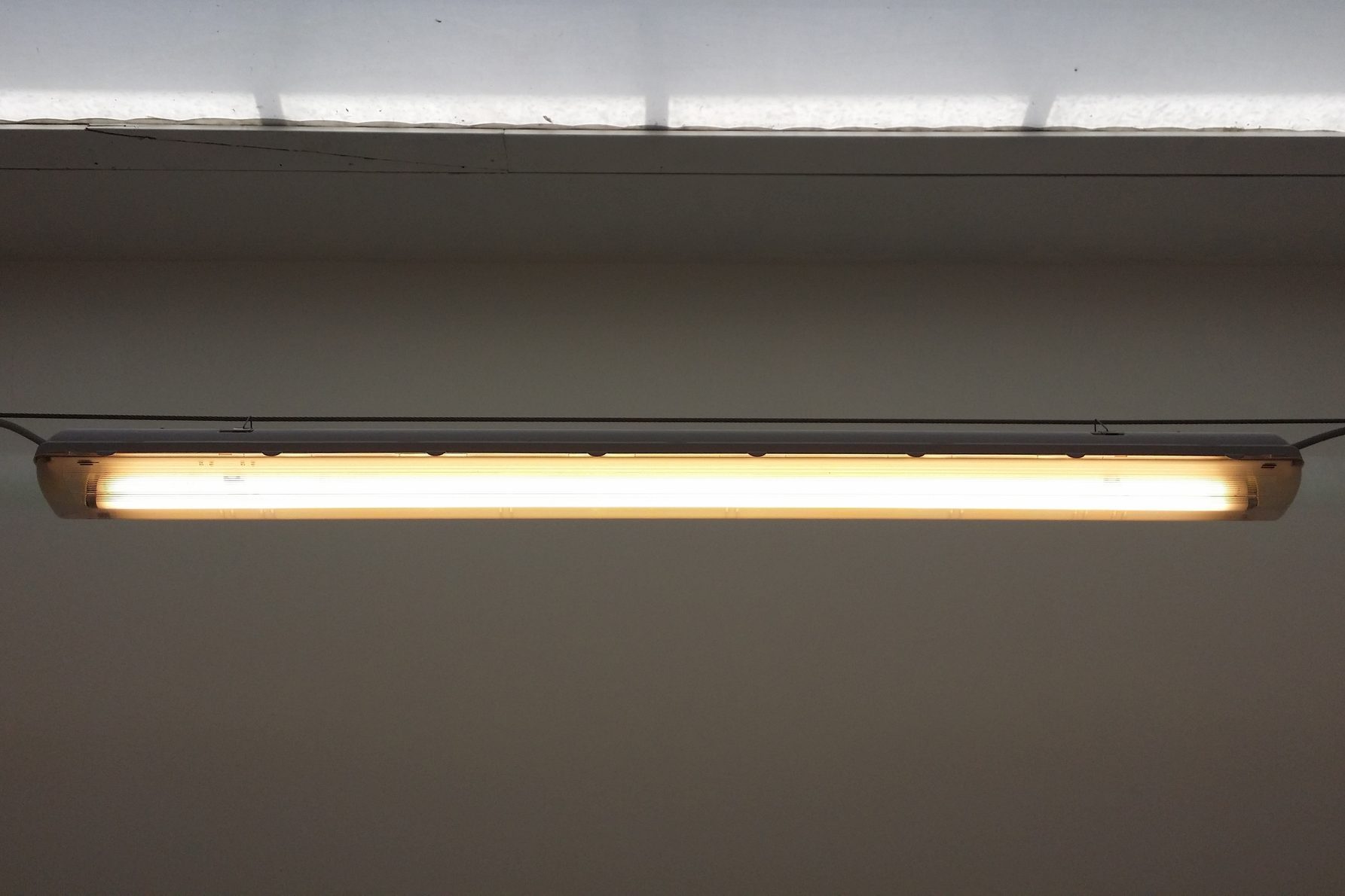 Low Angle View Of Illuminated Fluorescent Light On Wall