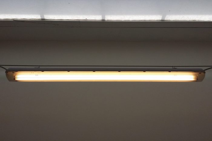 Low Angle View Of Illuminated Fluorescent Light On Wall