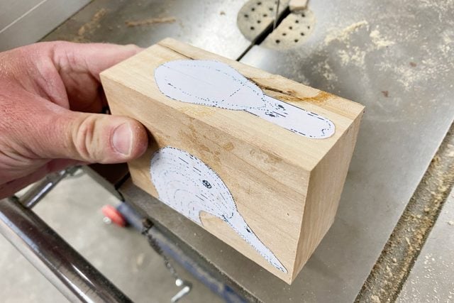 placing a duck head template onto a block of wood