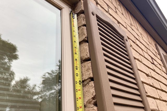 measuring a window with a tape measure