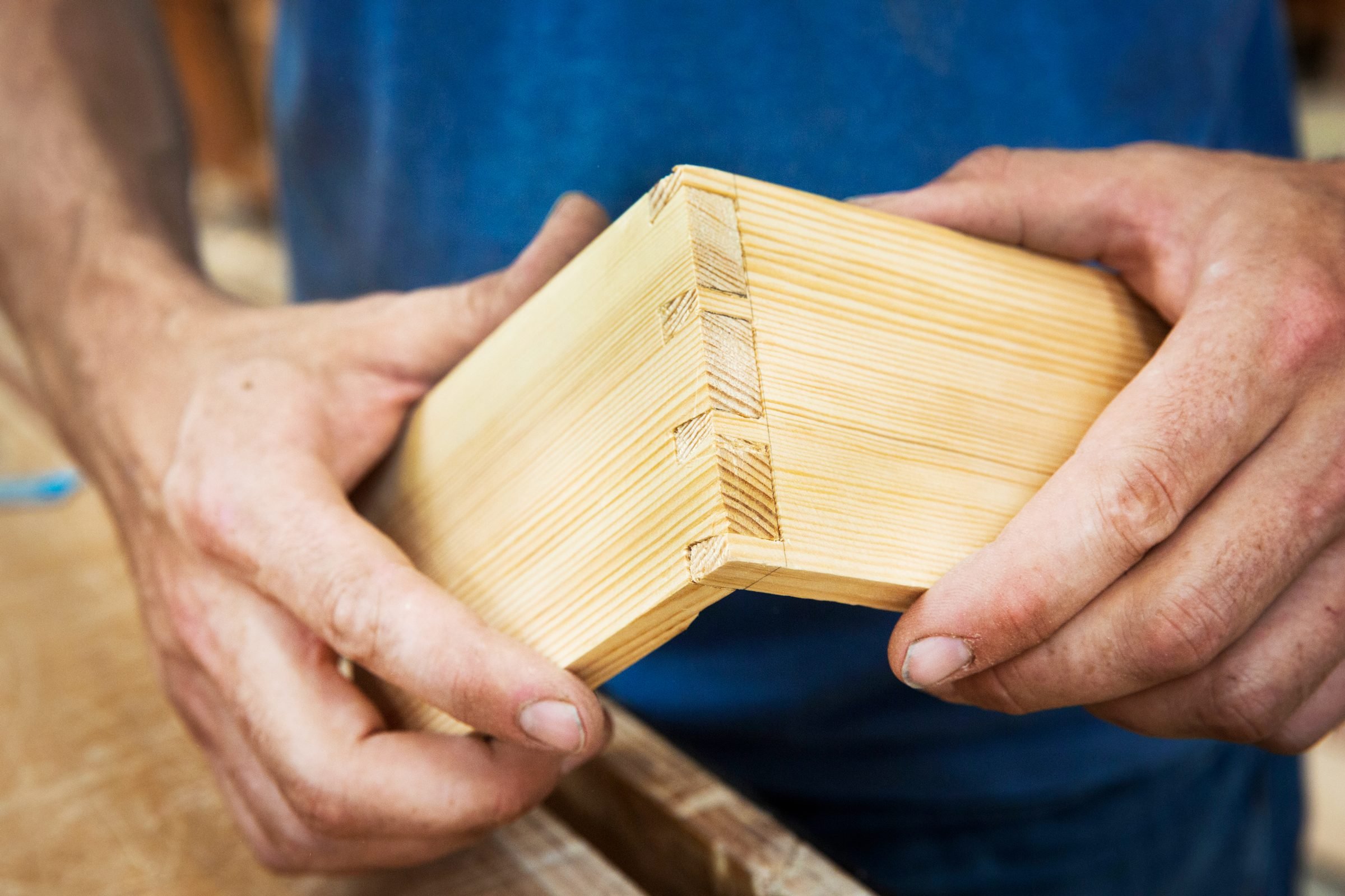 Close up of person working a boat-builders workshop, joining together two pieces of wood