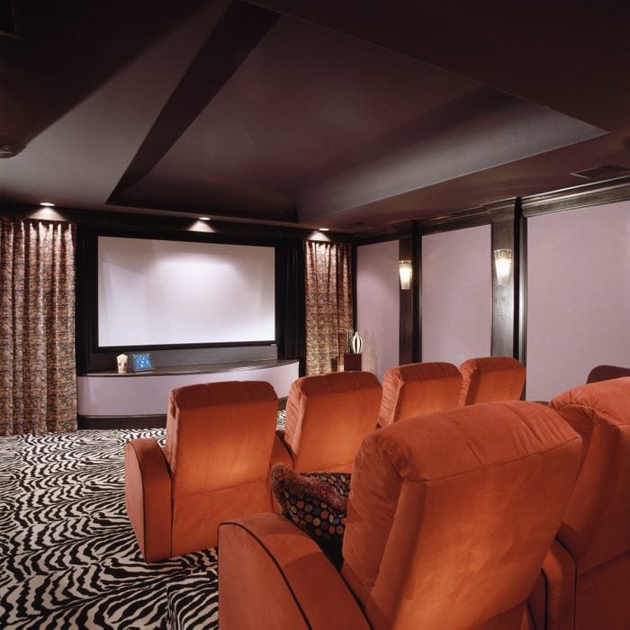 Home Theater with birght wall sconces and orange chairs