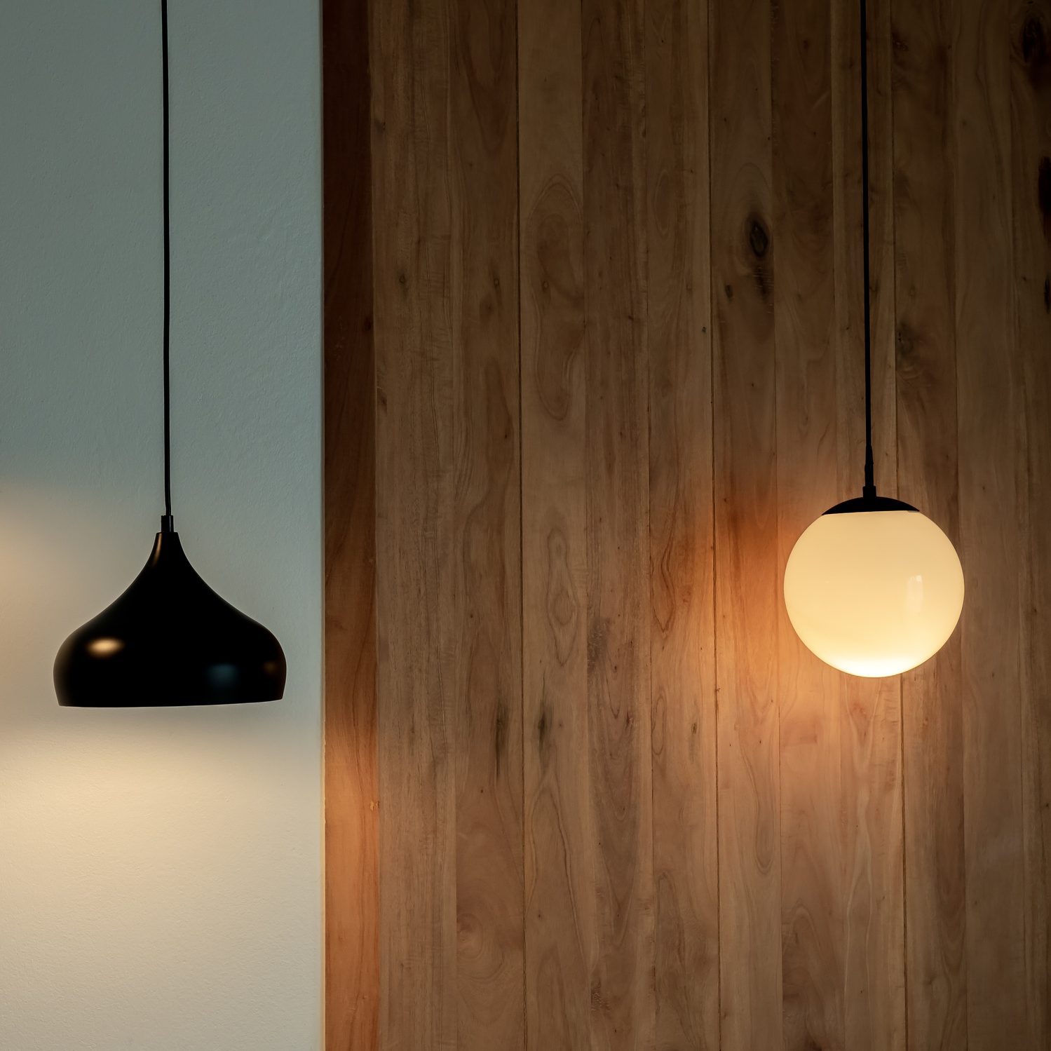 Twin ceiling lighting in the dark room. Two hanging lamp or round ceiling lamp decorated as a steps and round light full moon shape on white and wood wall.
