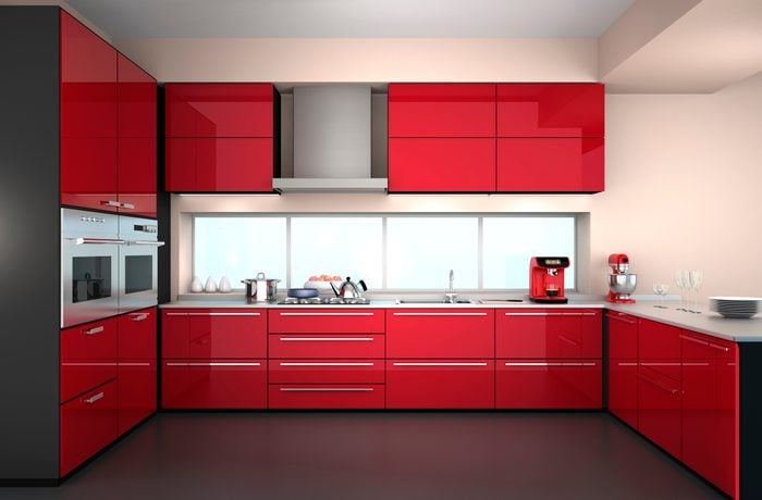 Front view of modern kitchen interior in red color theme.