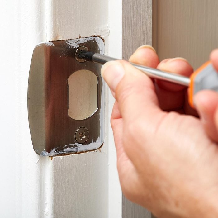 Door Strike Plate Installation with hand and screwdriver