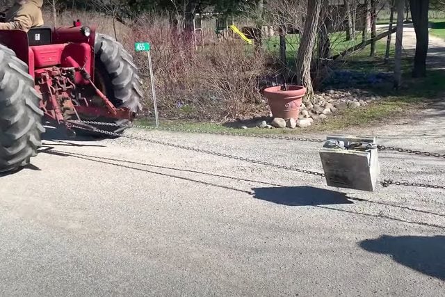 trying to pul apart fixed concrete block with a tractor