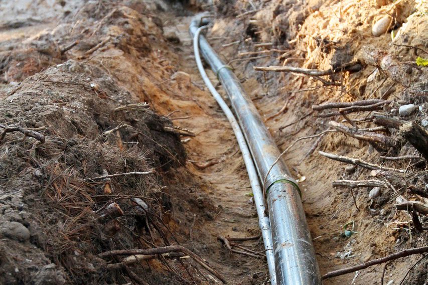 This large, black pipe encases an insulated and heated Heat-Line water pipe leading from a new well to a cottage. Even exposed like this to -15C temperatures, the water line remains frost free with the heating cable coming on only 30% of the time.