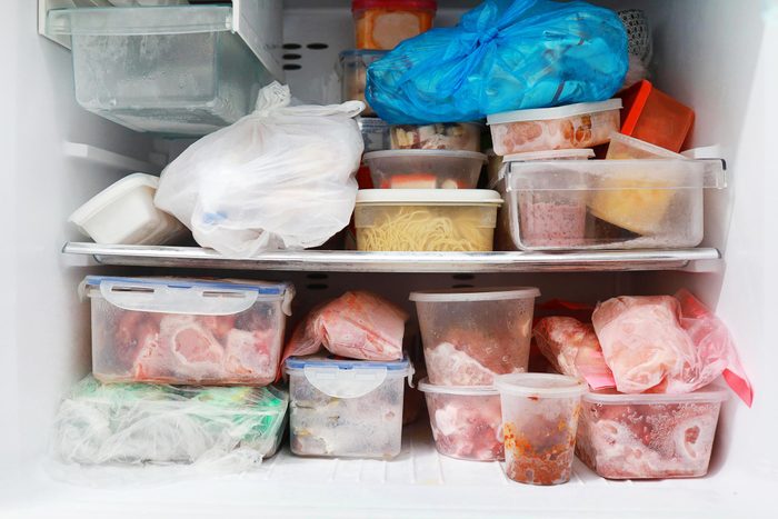 packed and messy freezer filled with containers in need of some spring cleaning