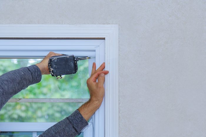 Construction worker installing window in house