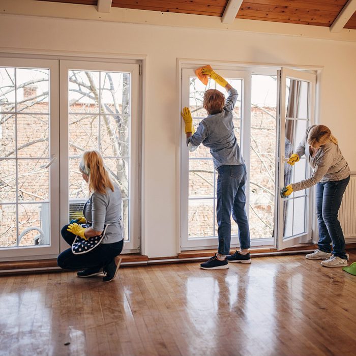 Women cleaning windows in apartment