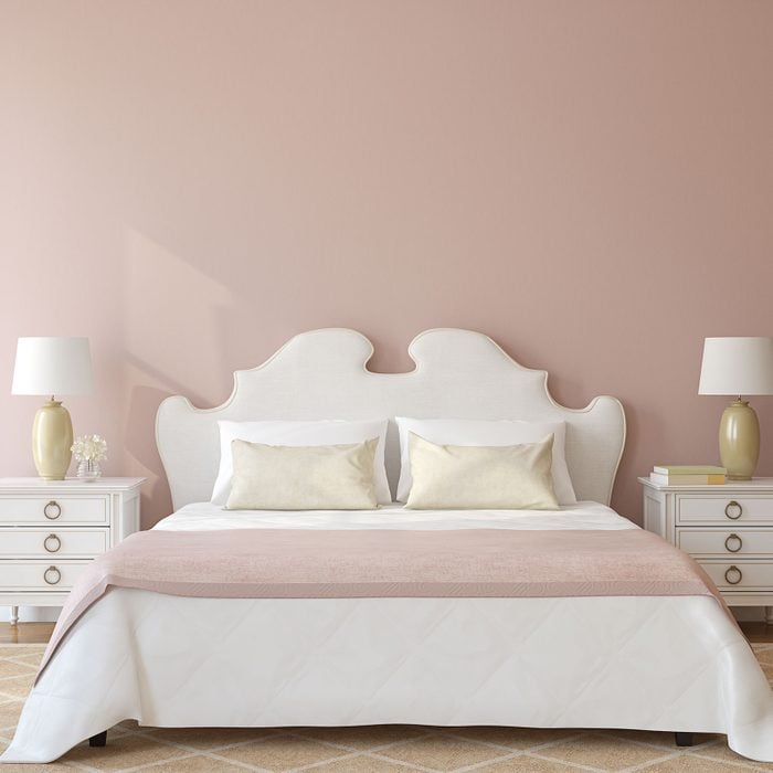 Bedroom Interior with white bed and nightstands on a blush pink dusty rose background