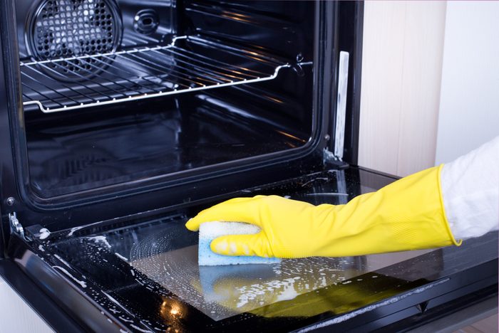 Woman cleaning oven