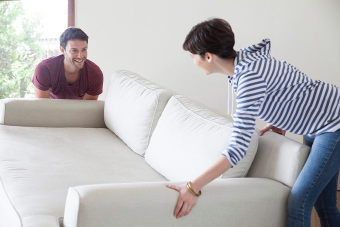 Couple moving sofa together