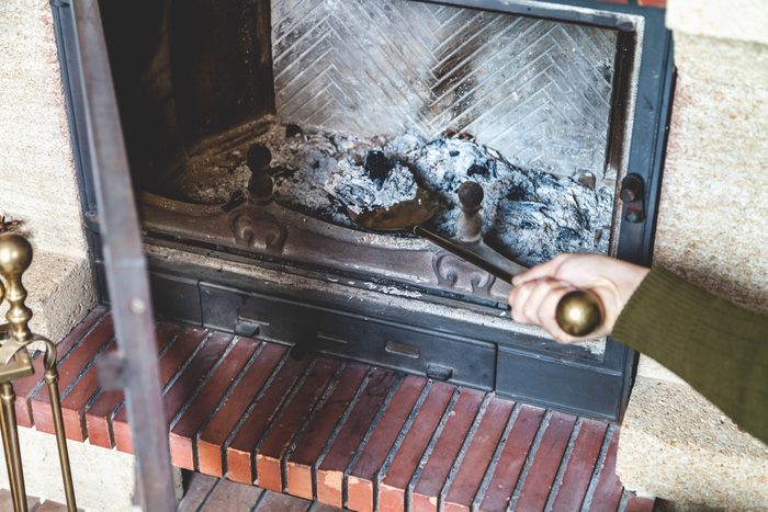 Cleaning fireplace. hand holding shovel with ash