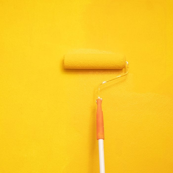 The Painter Is Painting The Yellow Wall In The Home