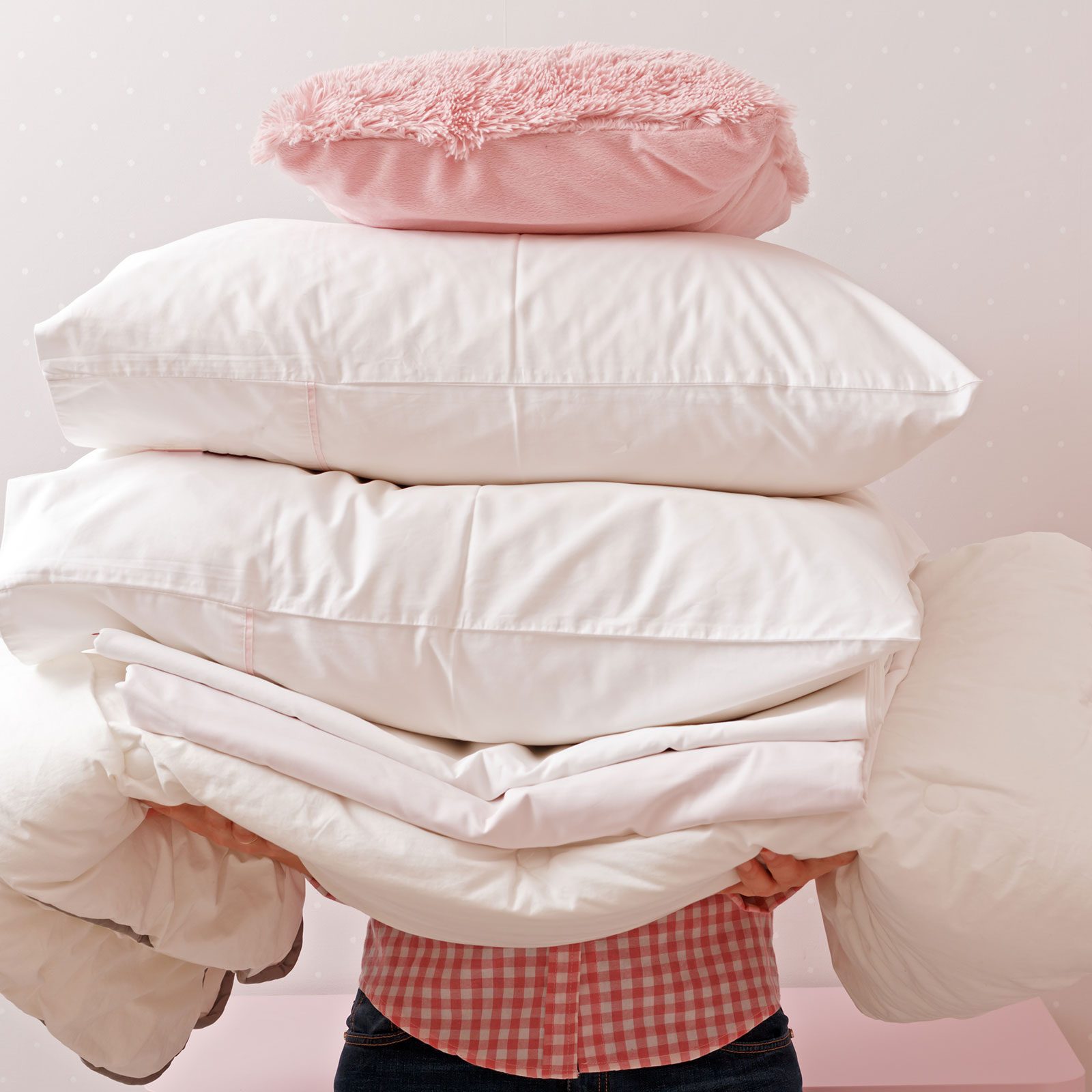 Woman Holding A Pile Of Bedding For Sleeping