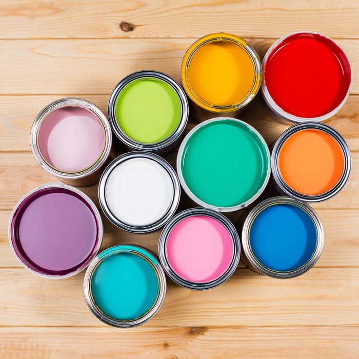 Top View of Metal Paint Bucks with colorful pigments placed on a wooden background