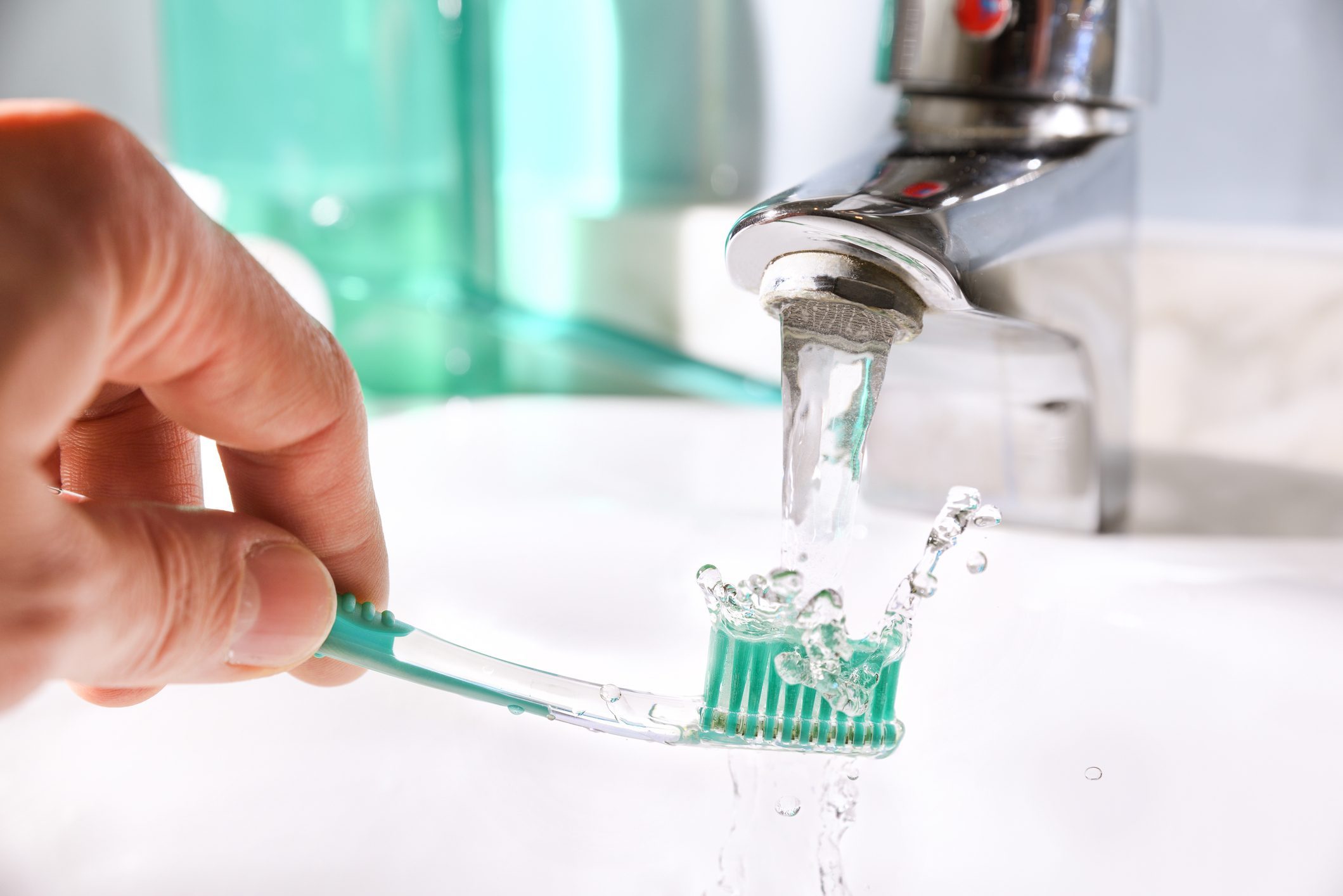 Daily Cleaning Of The Toothbrush After Use In Bathroom Sink