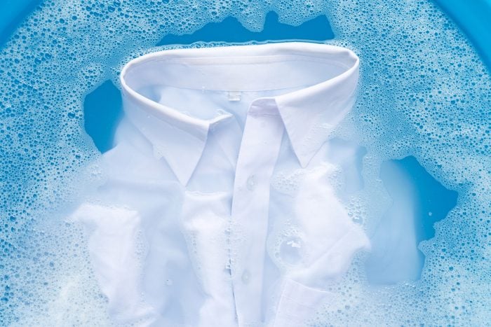 Close-Up Of White Shirt soaking in blue liquid