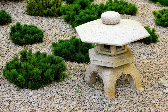 A japanese garden decoration with a stone lantern.