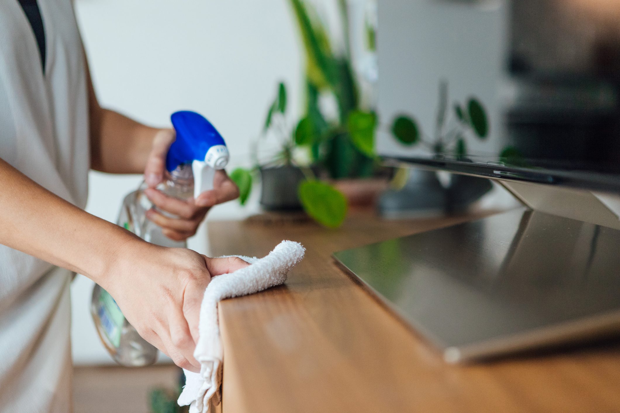 Cropped shot of a young woman cleaning the surface of a dresser with cleaning spray and cloth at home during the day
