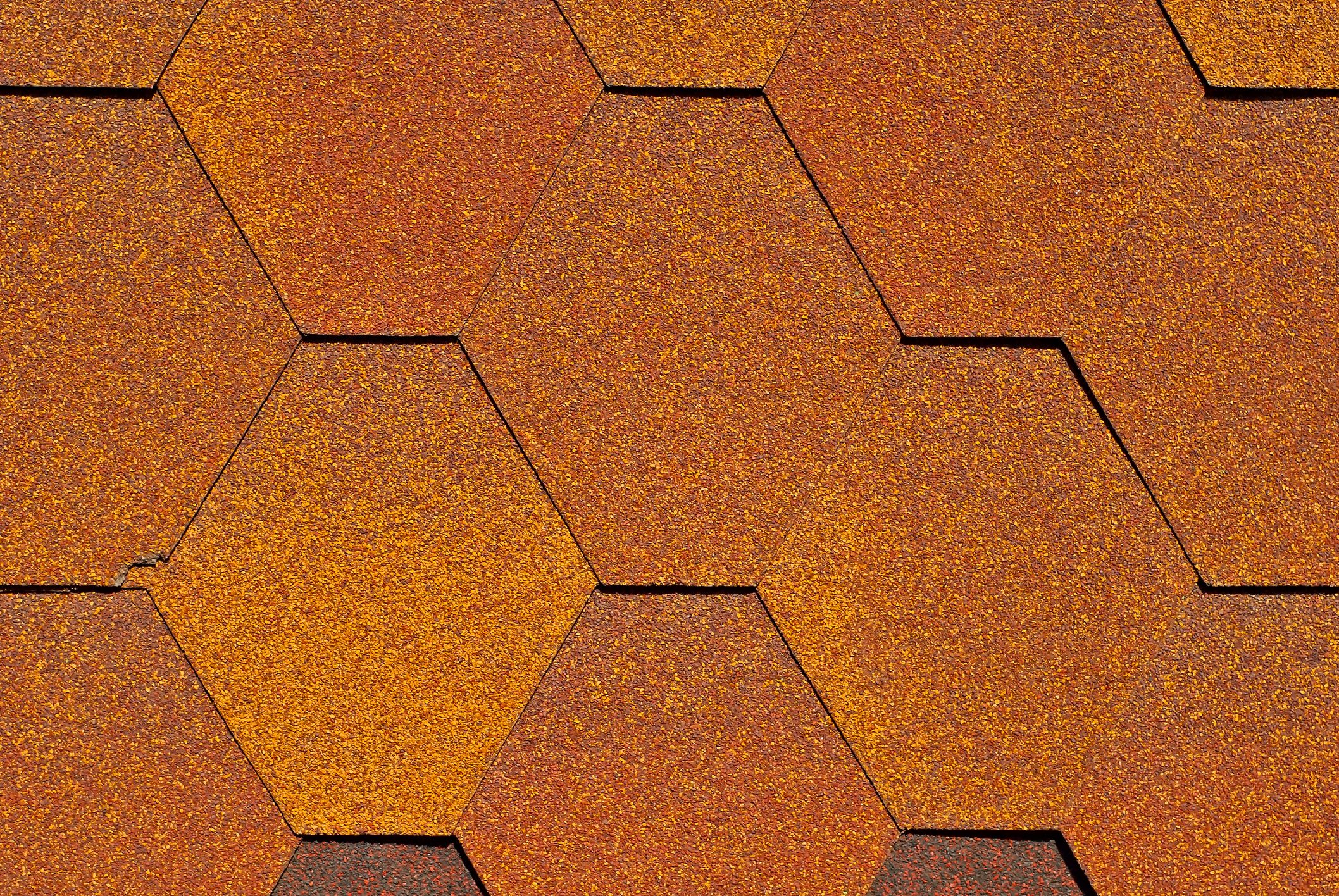 Flexible tile is made of fiberglass impregnated with bitumen. Texture of orange roof close up.