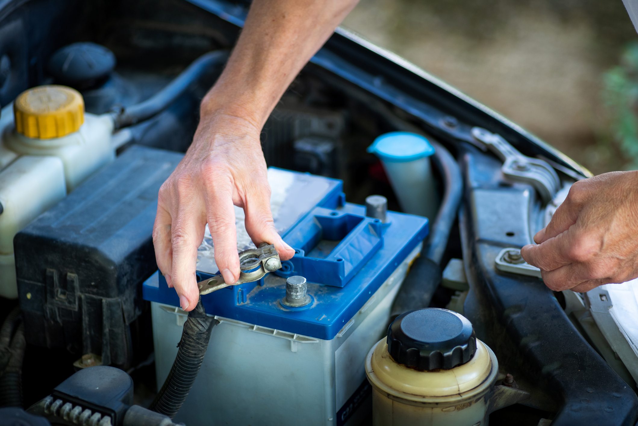 Man connecting the car battery to the vehicle