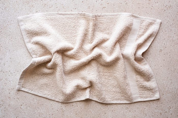 Close-up of folded bath towel on concrete background, top view