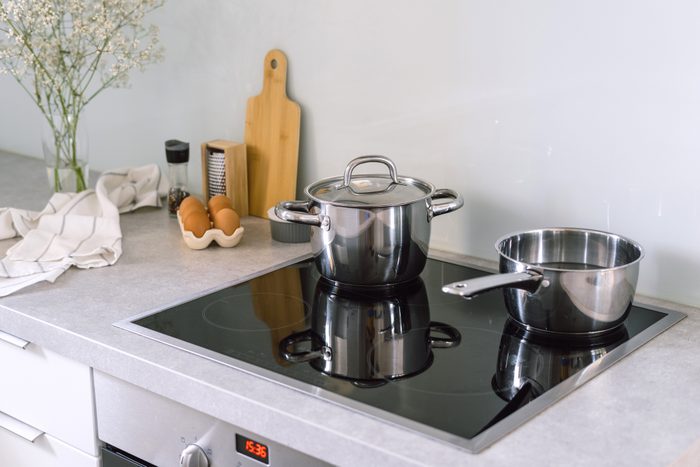 cooking pot and saucepan on electric stove at modern kitchen