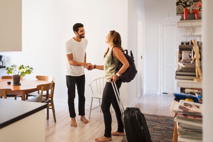 Happy man shaking hand with woman going for vacation