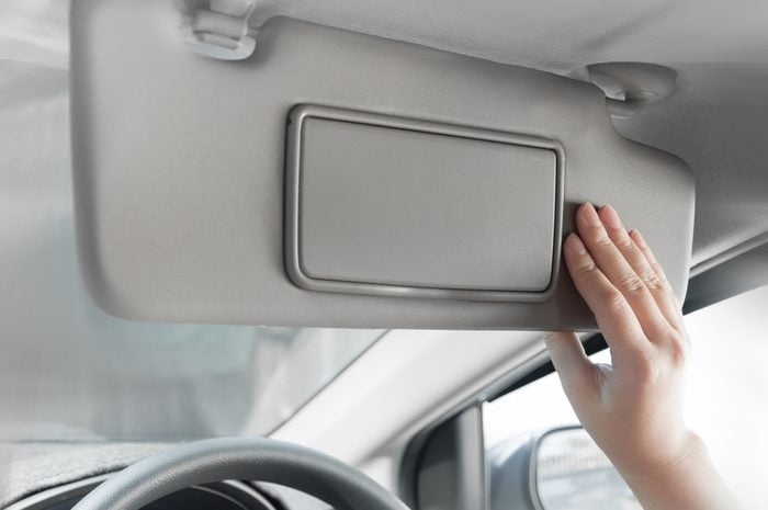hand holding sun visor interior inside car