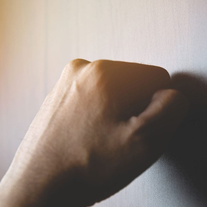 Male Knocks On A Wooden door or wall with his hand