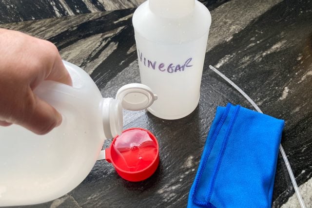 measuring white vinegar in a measuring cup