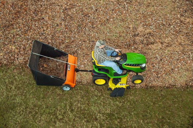 top view of a man on a tractor using a Agri Fab Lawn Sweeper