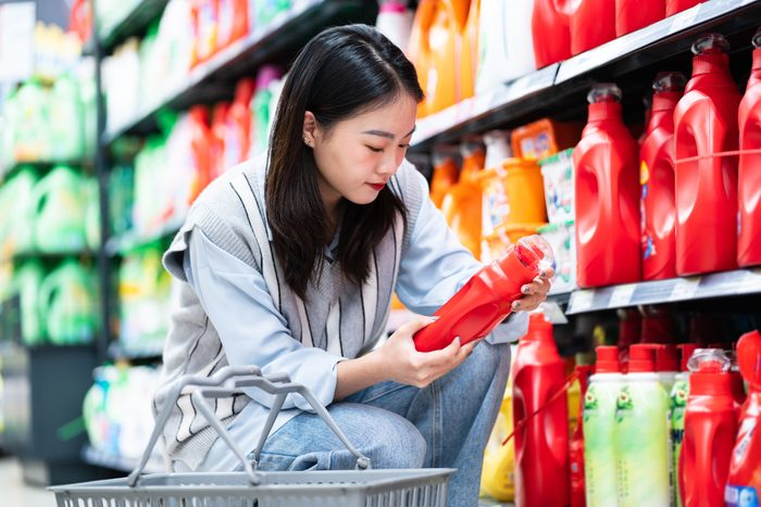asian Woman buys washing powder in supermarket
