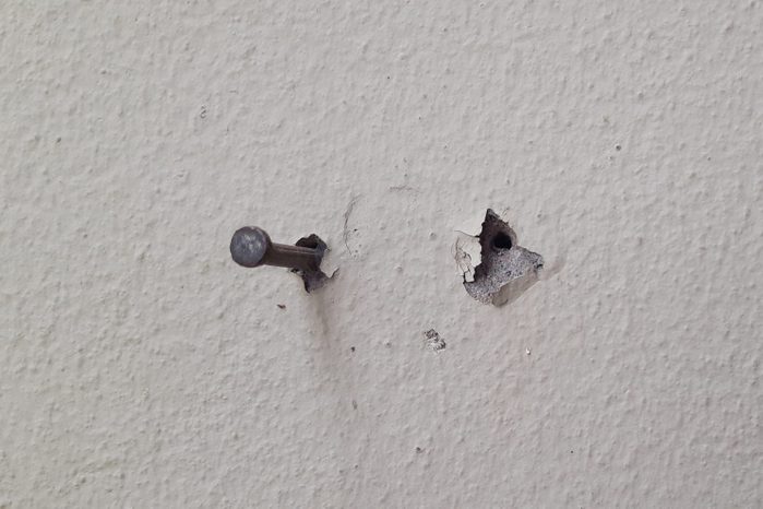 Concrete nails on wall background