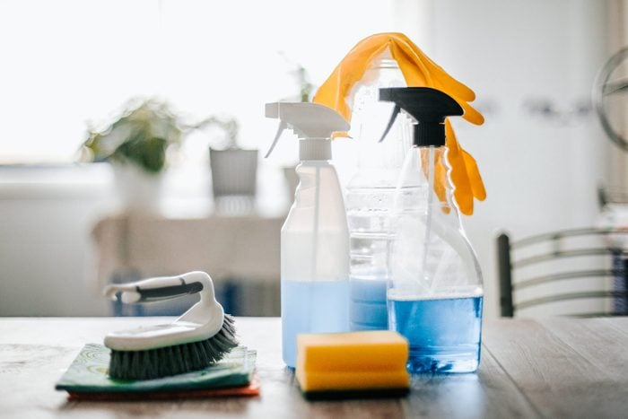 collection of cleaning supplies on surface of the kitchen table