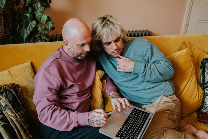 A gay couple use a laptop to shop online