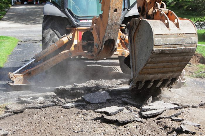 Backhoe Excavator Demolishing Old Residential Driveway