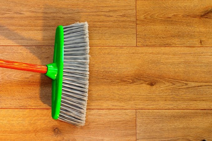 cleaning wooden floor with broom