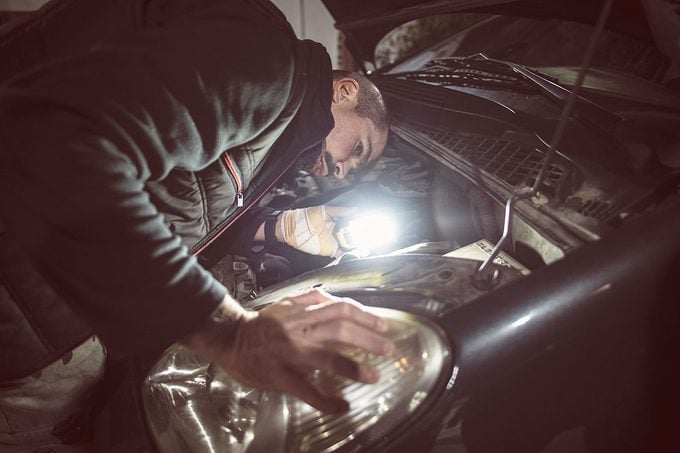mechanic repair car lights during a night emergency